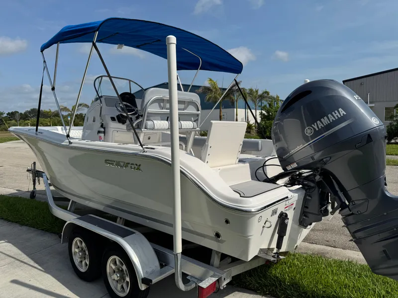 Slide: The Image of 2019 Sea Fox 206 Commander boat with Yamaha engine on trailer, blue canopy, sunny day. - 18