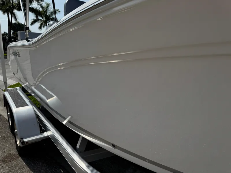 Slide: The Image of 2019 Sea Fox 206 Commander boat on trailer, side view with palm trees in background. - 25