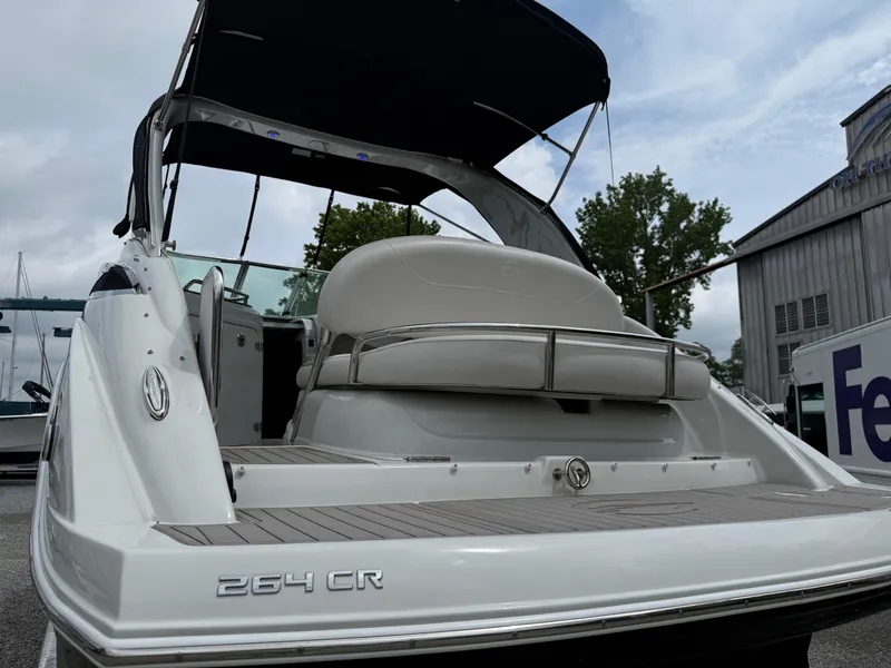 Slide: The Image of 2023 Crownline 264 CR boat with canopy, docked outdoors. - 10