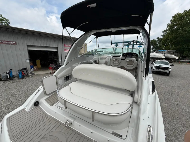 Slide: The Image of 2023 Crownline 264 CR boat with spacious seating and sleek design, docked outdoors. - 11