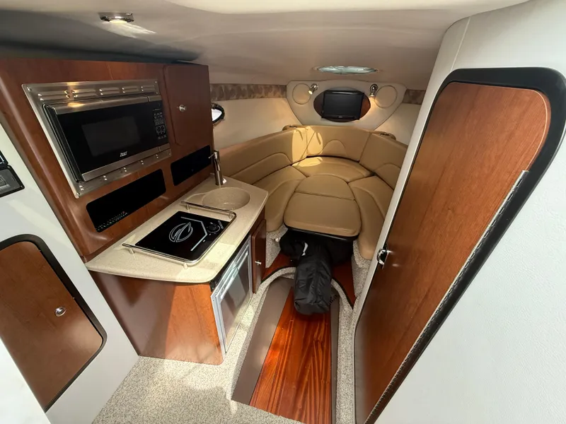 Slide: The Image of 2023 Crownline 264 CR cabin interior with kitchenette and seating area. - 18