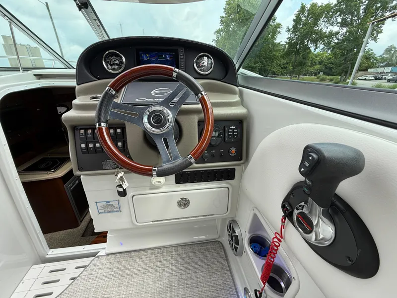 Slide: The Image of 2023 Crownline 264 CR boat cockpit with steering wheel and control panel. - 19