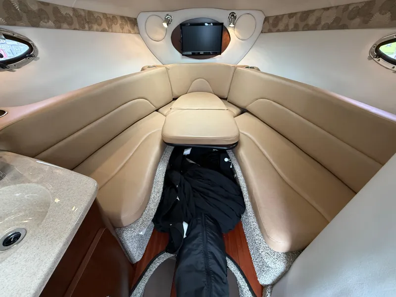 Slide: The Image of 2023 Crownline 264 CR cabin interior with beige seating and compact design. - 21