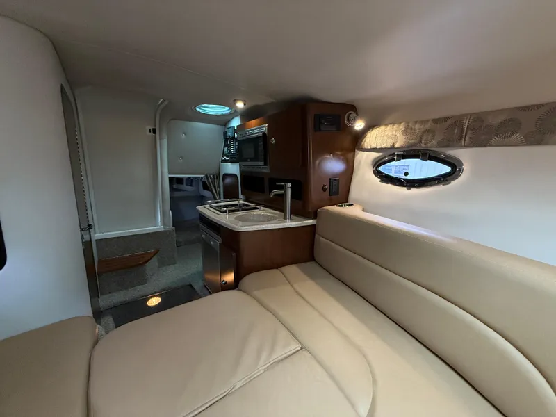 Slide: The Image of 2023 Crownline 264 CR cabin interior with kitchenette and seating area. - 23