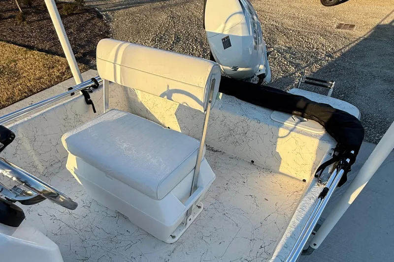 Slide: The Image of 2023 Coastal Skiff 171 boat interior with white seating and steering wheel. - 11