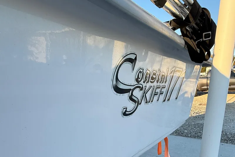 Slide: The Image of 2023 Coastal Skiff 171 boat side view with logo in sunlight. - 3