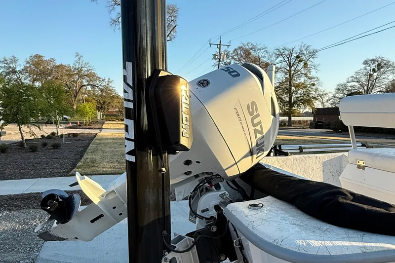 Slide: The Image of 2023 Coastal Skiff 171 with Suzuki outboard motor, docked in a sunny outdoor setting. - 4