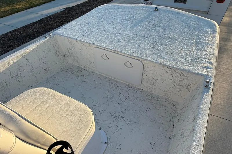 Slide: The Image of 2023 Coastal Skiff 171 boat interior with textured white finish and seating. - 8