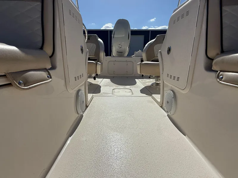 Slide: The Image of 2020 Carolina Skiff 21LS Dual Console interior with beige seating and clear sky view. - 10