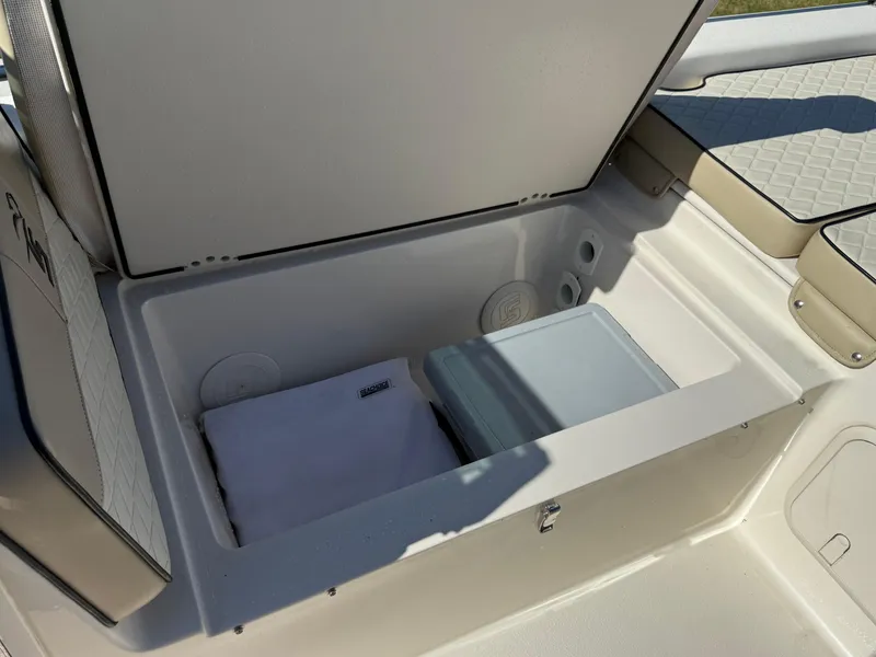 Slide: The Image of 2020 Carolina Skiff 21LS Dual Console storage compartment with towel and cooler. - 18