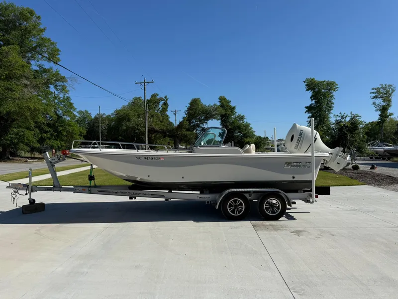 Slide: The Image of 2020 Carolina Skiff 21LS Dual Console boat on trailer, parked outdoors. - 2