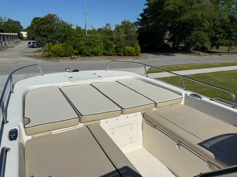 Slide: The Image of 2020 Carolina Skiff 21LS Dual Console boat with cushioned seating, parked outdoors. - 7