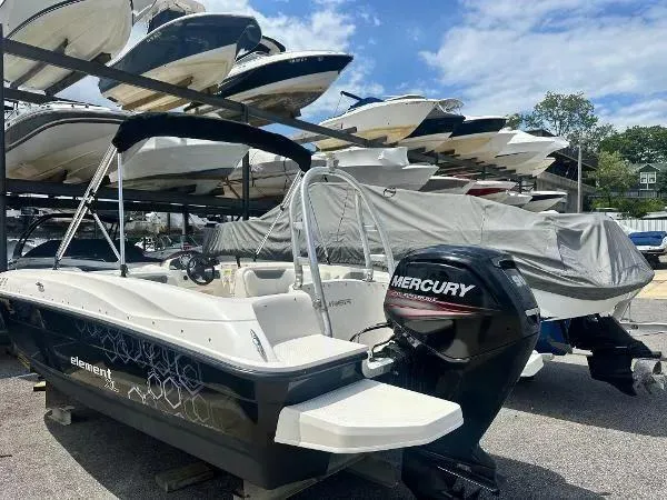 Slide: The Image of Bayliner Boats Element E180 2015 in storage, featuring a Mercury outboard motor. - 3