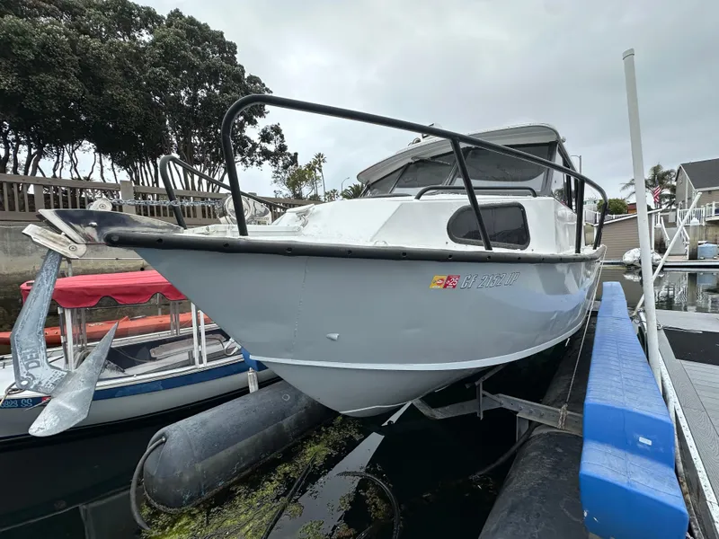 Slide: The Image of 1995 Almar 26 Sounder boat cruising in a sunny marina with palm trees. - 3