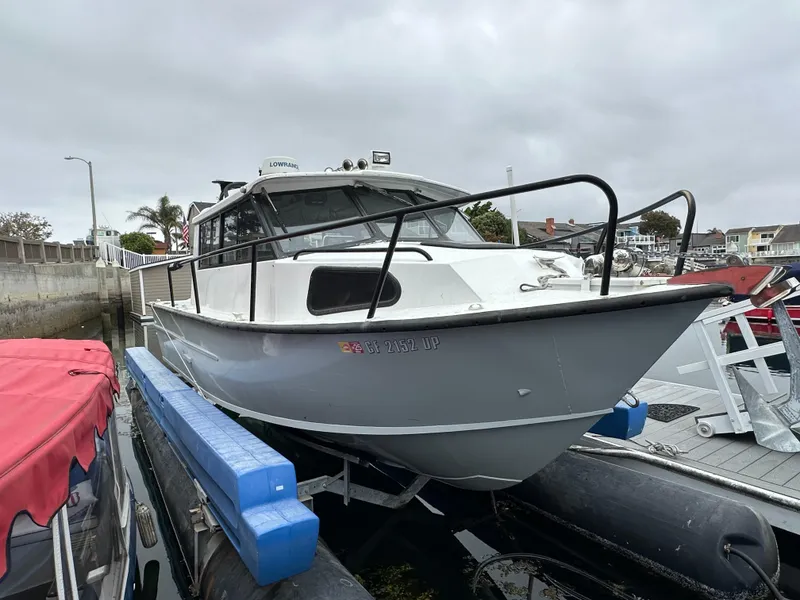 Slide: The Image of 1995 Almar 26 Sounder boat docked in a scenic marina with waterfront homes. - 4