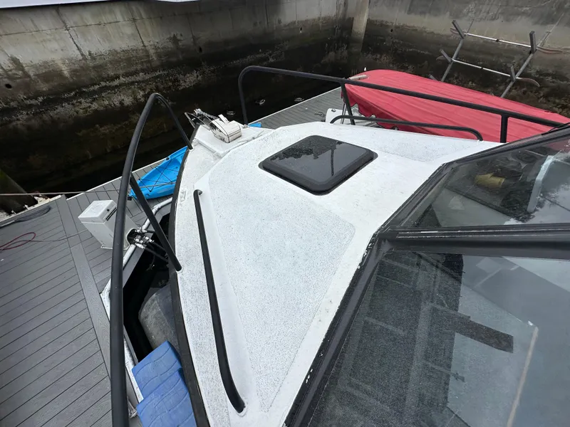 Slide: The Image of 1995 Almar 26 Sounder boat docked, featuring a white cabin and black railings. - 6
