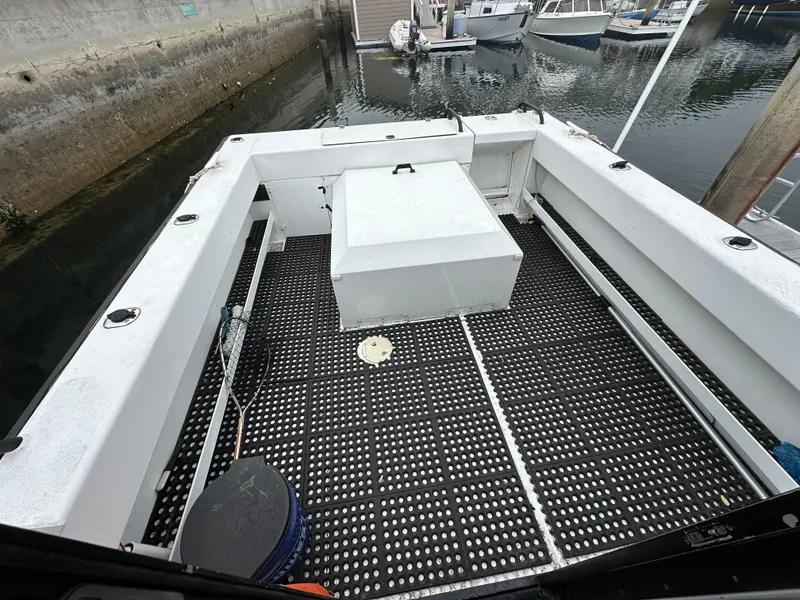 Slide: The Image of 1995 Almar 26 Sounder boat docked, featuring a sturdy hull and protective railing. - 8