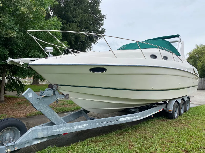 Slide: The Image of 1998 Regal 292 Commodore boat on trailer, parked outdoors, with green canopy. - 1