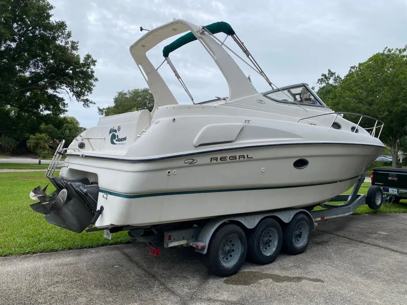 Slide: The Image of 1998 Regal 292 Commodore boat on a trailer, parked outdoors. - 10