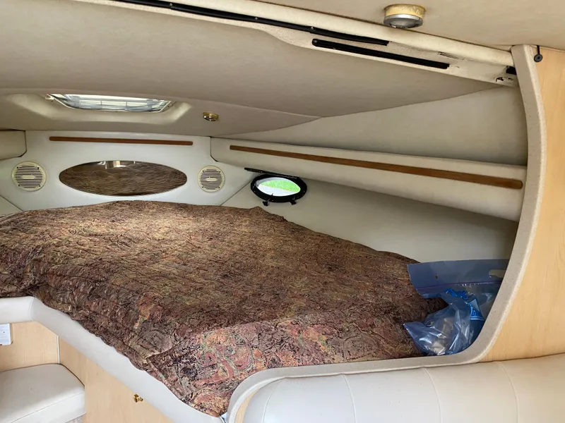 Slide: The Image of 1998 Regal 292 Commodore cabin interior with bed and porthole windows. - 14