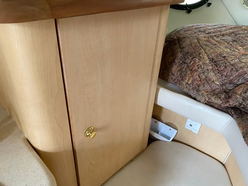 Slide: The Image of 1998 Regal 292 Commodore cabin interior with wood cabinet and cushioned seating. - 19