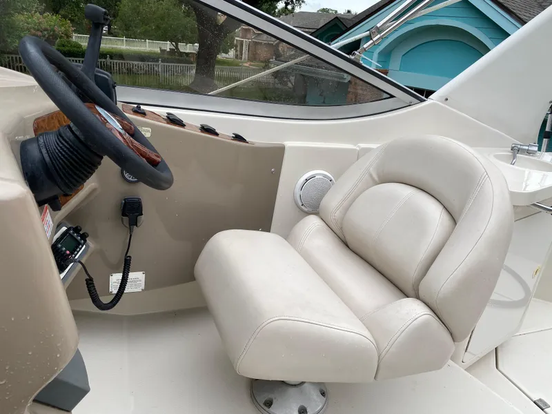 Slide: The Image of 1998 Regal 292 Commodore boat helm with beige captain's chair and steering wheel. - 23