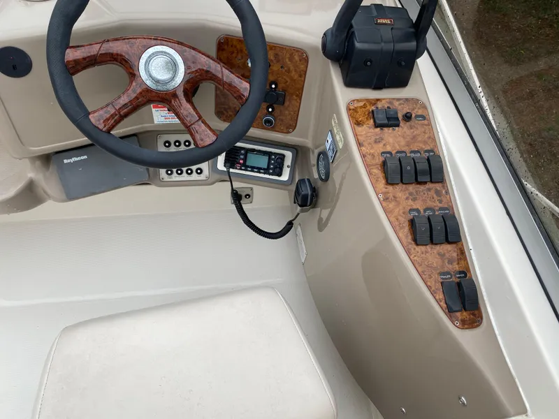 Slide: The Image of 1998 Regal 292 Commodore boat dashboard with wood accents and control panel. - 25