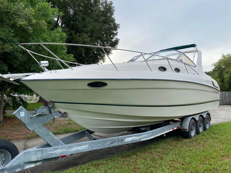 Slide: The Image of 1998 Regal 292 Commodore boat on a trailer, parked outdoors. - 29
