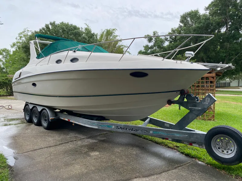 Slide: The Image of 1998 Regal 292 Commodore boat on trailer, parked outdoors on a driveway. - 3