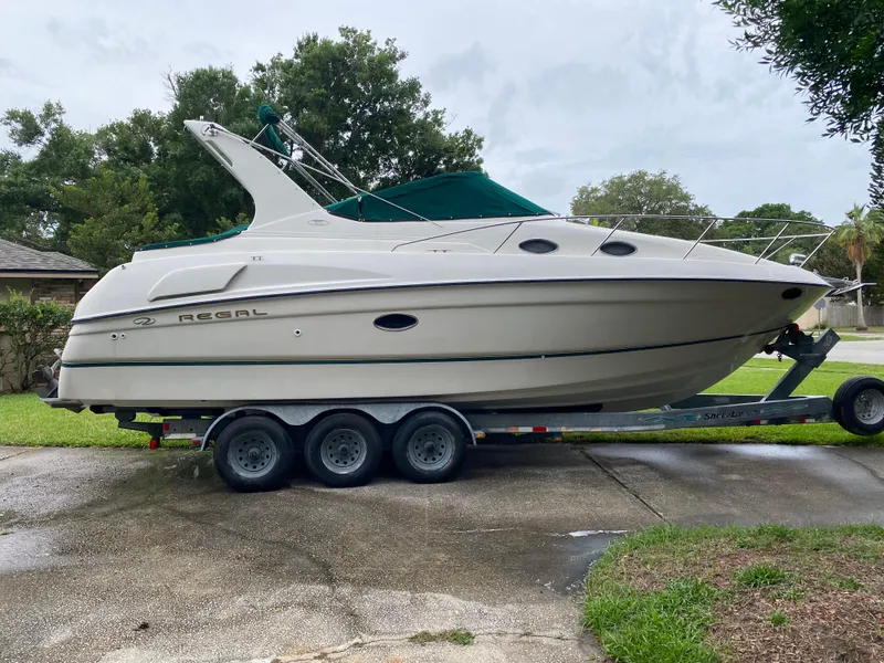 Slide: The Image of 1998 Regal 292 Commodore boat on trailer, parked outdoors, side view. - 4