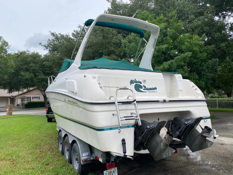 Slide: The Image of 1998 Regal 292 Commodore boat on trailer, parked outdoors with green canopy. - 6