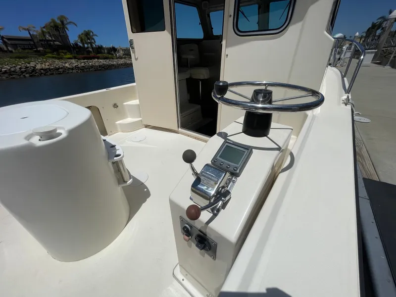 Slide: The Image of 2008 Parker 2520 XL Sport Cabin boat helm with steering wheel and controls. - 11
