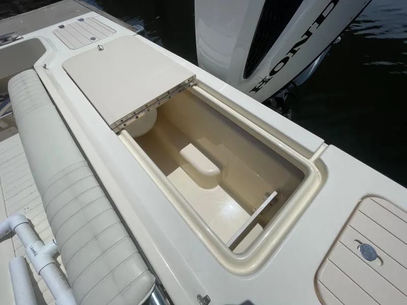 Slide: The Image of 2008 Parker 2520 XL Sport Cabin boat with open storage compartment and Honda engine. - 15