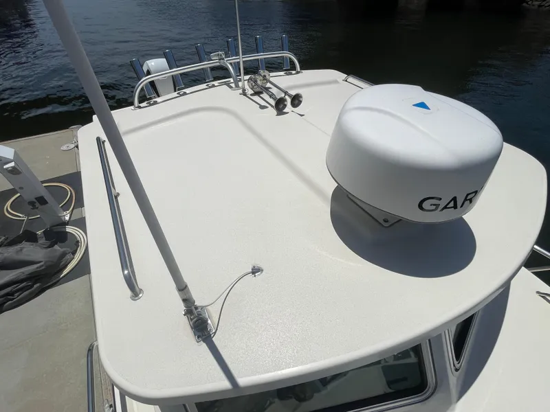 Slide: The Image of 2008 Parker 2520 XL Sport Cabin boat roof with radar, docked by water. - 6