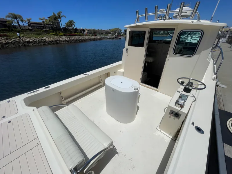 Slide: The Image of 2008 Parker 2520 XL Sport Cabin boat docked by a scenic waterfront. - 7