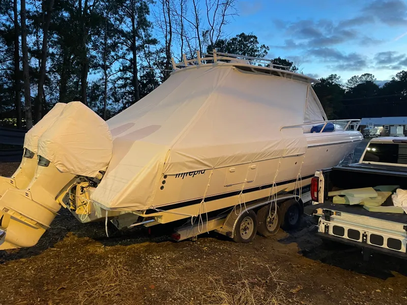 Slide: The Image of 2007 Intrepid 35 Walkaround boat covered and on a trailer, parked outdoors. - 12