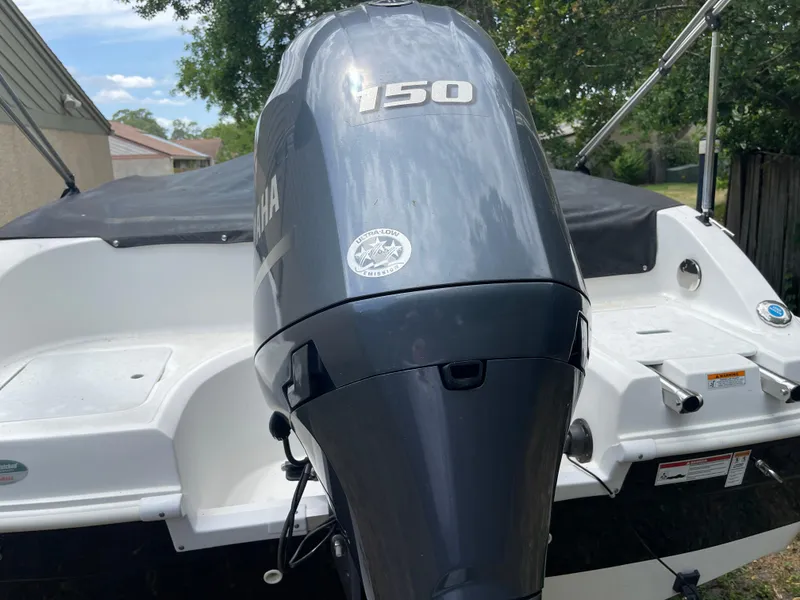 Slide: The Image of 2022 Hurricane SunDeck Sport 188 OB with Yamaha 150 outboard motor, parked outdoors. - 16
