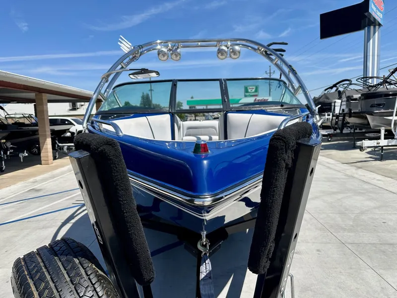 Slide: The Image of 2006 Calabria Boats Wakeboard Boat Cal-Air Pro-V, blue, parked on trailer under clear sky. - 3