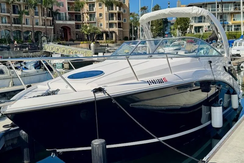 The Image of 2020 Regal 26 XO boat docked at marina with modern buildings in background. - 0