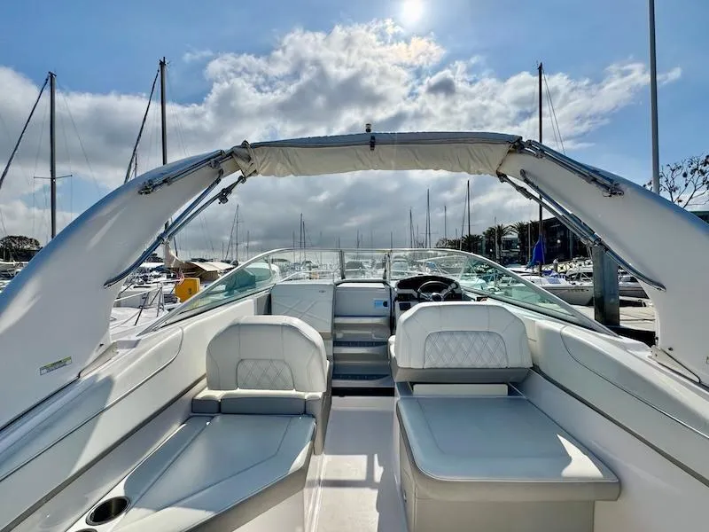 Slide: The Image of 2020 Regal 26 XO boat interior with plush seating and clear sky background. - 12