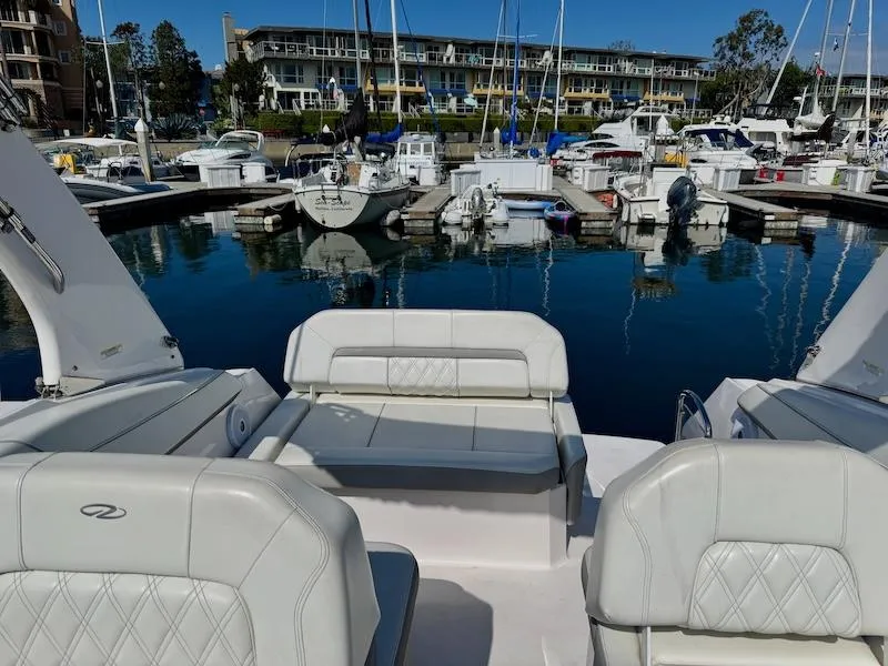 Slide: The Image of 2020 Regal 26 XO boat interior with white seating at marina. - 17