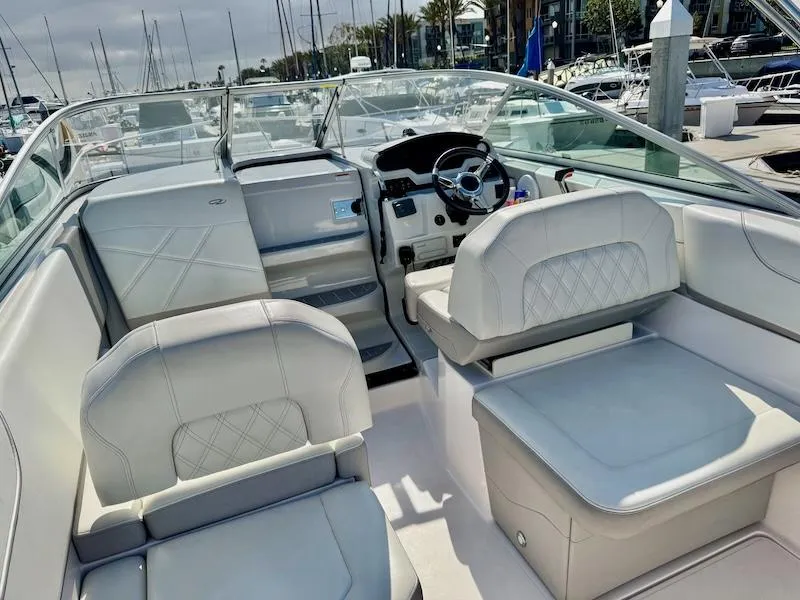 Slide: The Image of 2020 Regal 26 XO boat interior with white seating and steering wheel at marina. - 18