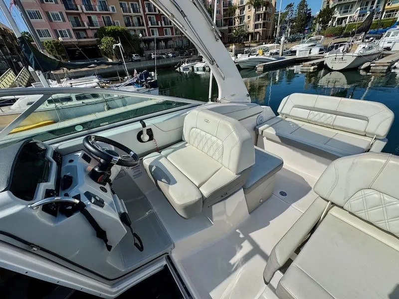 Slide: The Image of 2020 Regal 26 XO boat interior with white seating, docked in a marina. - 20