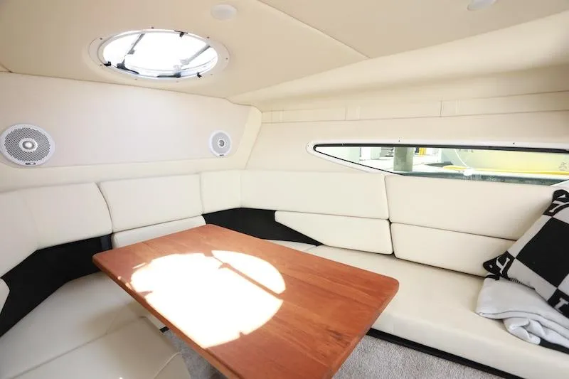 Slide: The Image of 2020 Regal 26 XO cabin interior with white seating and wooden table. - 28