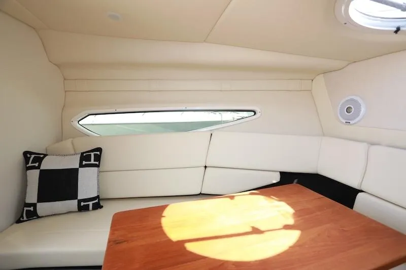 Slide: The Image of Interior of 2020 Regal 26 XO boat with cushioned seating and wooden table. - 29