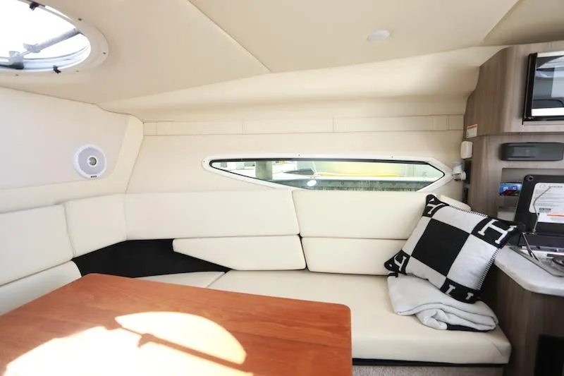 Slide: The Image of 2020 Regal 26 XO cabin interior with white seating, wooden table, and modern decor. - 30