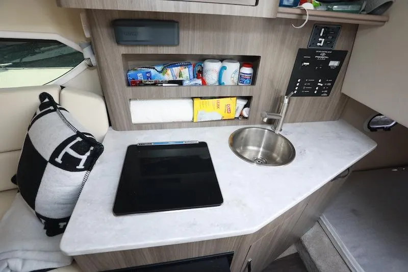 Slide: The Image of Compact kitchenette in 2020 Regal 26 XO boat with sink, storage, and control panel. - 32