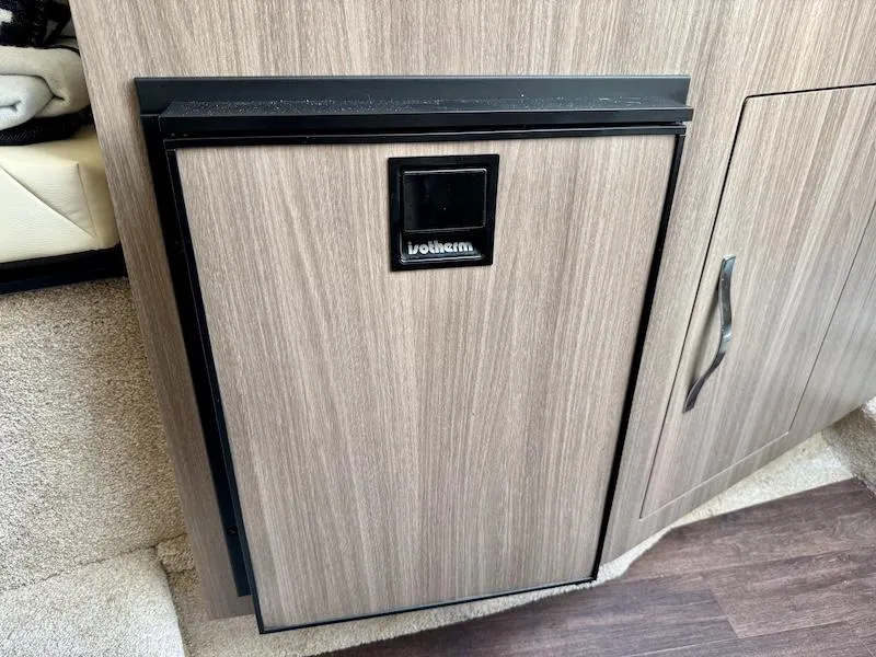 Slide: The Image of Compact fridge in 2020 Regal 26 XO boat interior, featuring wood paneling and modern design. - 34