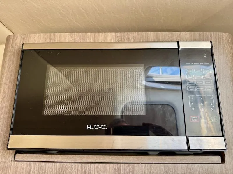Slide: The Image of Microwave oven inside a 2020 Regal 26 XO boat, featuring a sleek black and silver design. - 36