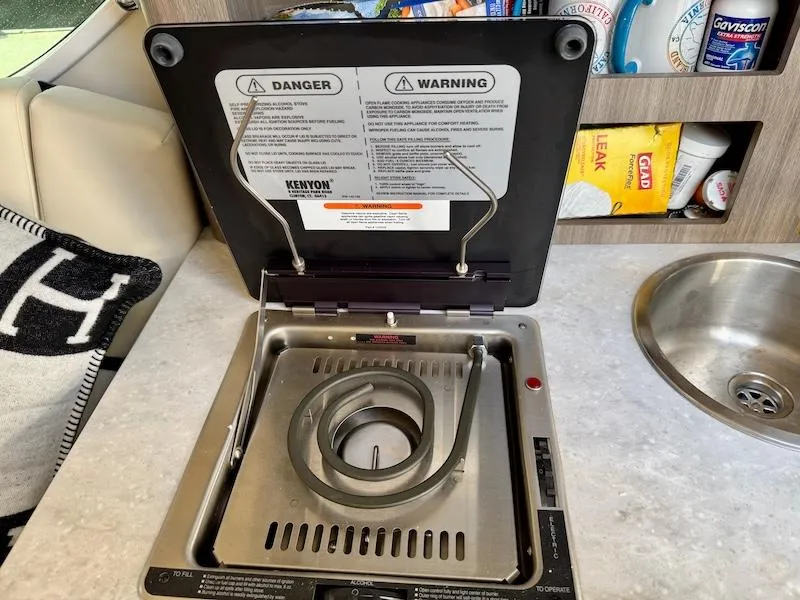 Slide: The Image of Electric stove in a 2020 Regal 26 XO boat kitchen area. - 37